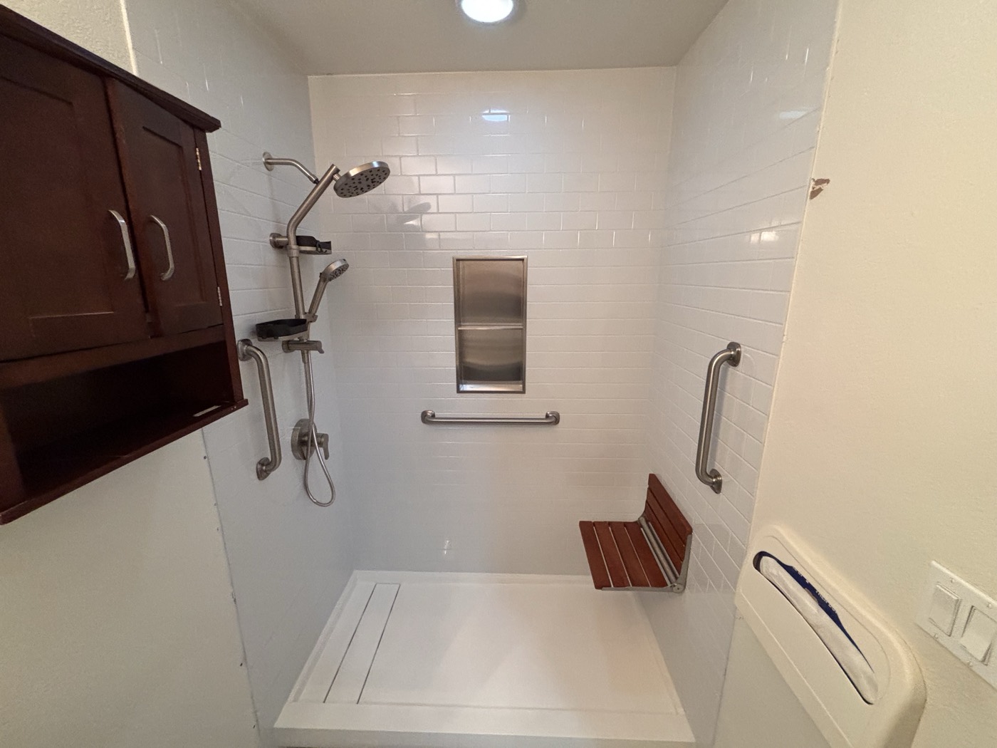 Low-threshold walk-in shower with grab bars and a fold-down bench